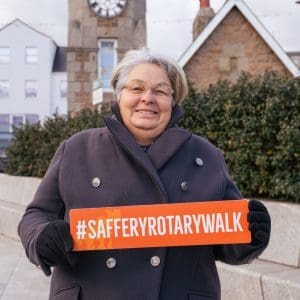 Carol Le Page holding a sign #SafferyRotaryWalk