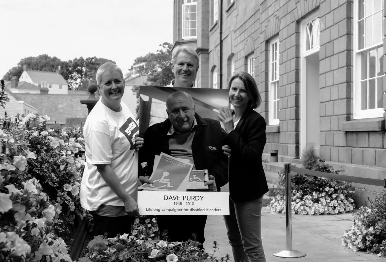 Karen Rob and Shelaine with poster of Dave Purdy on the steps of the States